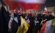 Veiled Iranian women shout anti-U.S. and anti-Israeli slogans as they wave national flags...