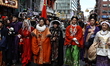 Performers in Chinese traditional costumes march in the Chinese New Year parade in the str...