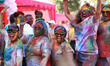 Tourists are smeared in 'gulal' colors during an event organized by Rajasthan Tourism for...