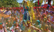 Tourists are smeared in 'gulal' colors during an event organized by Rajasthan Tourism for...