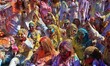 Tourists are smeared in 'gulal' colors during an event organized by Rajasthan Tourism for...