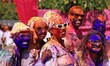 Tourists are smeared in 'gulal' colors during an event organized by Rajasthan Tourism for...