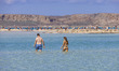 View of a young woman wearing a bikini in Balos lagoon with the warm sandy beach on the Gr...