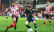 Luke Young of Cheltenham Town races to intercept the ball from Elliot Newby of Barrow AFC...