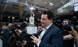 Coach Patrick Massaroni holds the trophy, with media surrounding him from all sides during...