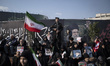 An armed Iranian policeman monitors an area while standing guard during a rally to pledge...