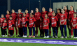 Malta players stand with player escorts during the playing of their country's national ant...
