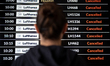 A passenger checks the Lufthansa flight status, and the airport arrivals and departures bo...