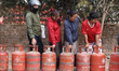 Nepali consumers wait in line carrying empty LPG cylinders as they rush to gas depots to r...