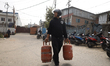Nepali consumers carry empty LPG cylinders as growing tensions in West Asia halt the suppl...