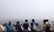 People overlook the polluted haze covering Kathmandu Valley from a hill station in Kathman...