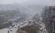 Vehicles ply on the roads of Kathmandu, Nepal, on March 12, 2026, as polluted haze covers...
