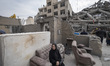 An Iranian woman sits on a sofa outside her apartment, which is destroyed during the U.S.-...