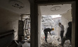 Iranian men work on the ruins of a building that is destroyed during the U.S.-Israeli mili...