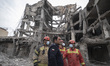A group of Iranian firefighters gathers on the ruins of buildings that are destroyed durin...