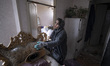 An Iranian woman stands at her apartment that is damaged during the U.S.-Israeli military...