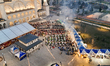 An aerial view captures hundreds of Muslims gathered at long tables for a communal Iftar m...