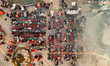 An aerial view captures hundreds of Muslims gathered at long tables for a communal Iftar m...
