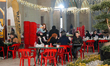 Muslim families and individuals gather at outdoor tables for a mass community Iftar meal u...