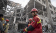 An Iranian firefighter stands on the ruins of buildings that are destroyed during the U.S....