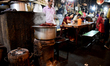 A man cooks using coal-fired ovens amid a shortage of commercial LPG cylinders in Kolkata,...
