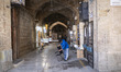 A young Iranian shopkeeper checks a chair while standing outside his shop in a traditional...