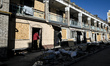 A man enters the entrance of an apartment building damaged by a Russian strike with guided...