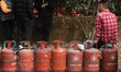 Nepali residents stand in line with empty LPG cylinders during a cooking gas shortage in K...