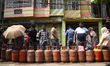 People wait in a long queue to buy liquefied petroleum gas (LPG) cylinders for domestic us...