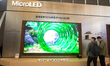 Fairgoers take pictures at the RGB mini LED screen at the Hisense booth at the SNEIC Expo...