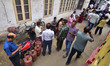 People stand in a long queue to collect LPG cylinders after information about availability...