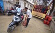 People stand in a long queue to collect LPG cylinders after information about availability...