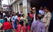 People stand in a long queue to collect LPG cylinders after information about availability...