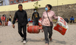 Nepali consumers carry half-filled gas cylinders from the Nepal Oil Corporation depot in K...