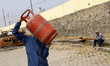 Nepali consumers carry half-filled gas cylinders from the Nepal Oil Corporation depot in K...