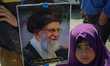 A Shiite Muslim child holds a portrait of Iran's late Supreme Leader Ayatollah Ali Khamene...