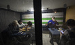 Iranian youths play backgammon at a cafe whose shutter is closed to protect customers from...