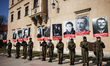 Participants hold banners while attending an official ceremony during the National Remembr...