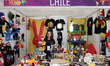 A woman sells products from Chile, including items from 31 Minutos, at the World Fair in t...
