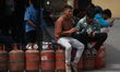 Nepali consumers queue to receive partially filled Liquefied Petroleum Gas (LPG) cylinders...