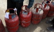 People wait in a queue to refill gas cylinders at a gas agency in Sopore, Jammu and Kashmi...