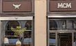 MCM luxury fashion store displays handbags and leather goods in the storefront on Maximili...