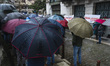 Participants with umbrellas protect themselves from the rain in the Plaza de las Atarazana...