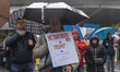 A person holds a banner during a rally calling for peace, sovereignty, and international s...