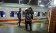 People carrying luggage walk toward the train cars at Kiaracondong Station in Bandung, Wes...