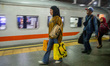 People carrying luggage walk toward the train cars at Kiaracondong Station in Bandung, Wes...