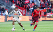 Justin Che (#2) of New York Red Bull dribbles the ball while being chased by Emilio Aristi...