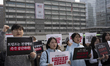 University students hold signs and chant slogans during a press conference in front of the...