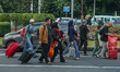 People carry their luggage toward buses at the National Monument in Jakarta, Indonesia, on...