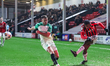 Daniel Kanu of Walsall FC crosses the ball to the center beyond James Gibbons of Cambridge...